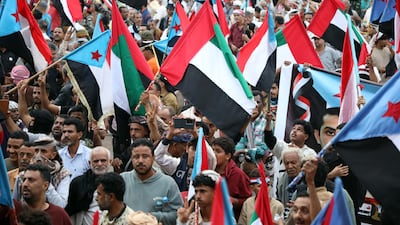 People wave UAE flags at a demonstration in Aden, which Emirati forces helped to free from the Houthis in 2015. EPA