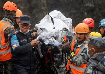 Rescuers recover the body of a victim from the site of the plane crash. Reuters