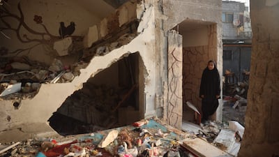 A woman stands beside a building targeted by an Israeli air strike near the Nuseirat refugee in central Gaza on Thursday. AFP