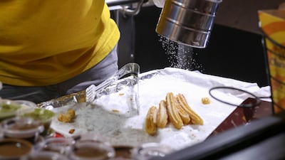 A vendor makes the churros on the spot for guests.
