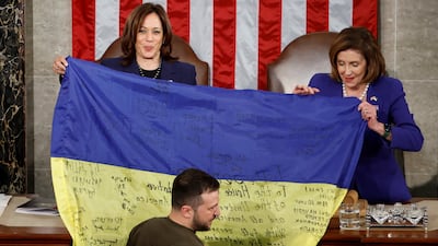 Ukrainian President Volodymyr Zelenskyy presents a flag to Vice President Kamala Harris and House Speaker Nancy Pelosi. Reuters