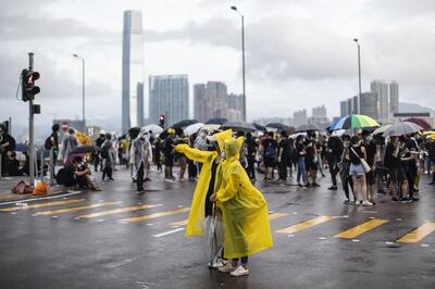 Demonstrators wear yellow raincoats as others gather on Lung Wo Road near the Central Government Complex during a protest in Hong Kong, China, on Monday, July 1, 2019. Bloomberg
