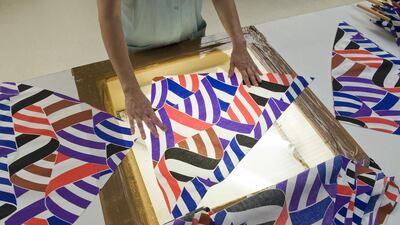 A worker checks fabrics for potential defects. Thierry Zoccolan / AFP