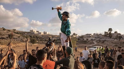 A Palestinian jockey celebrates after winning a horse race in Al Majd, west of the occupied West Bank city of Hebron. AFP