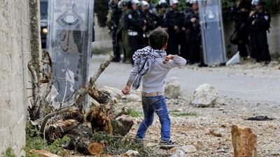 A young Palestinian boy get ready to throw a stone at Israeli soldiers during clashes near the the West Bank city of Nablus. Alaa Badarneh / EPA