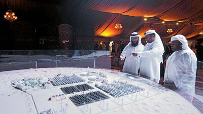 Officials and delegates from Dewa look at a model that represents the entire proposed Mohammed bin Rashid Al Maktoum Solar Park. Antonie Robertson / The National