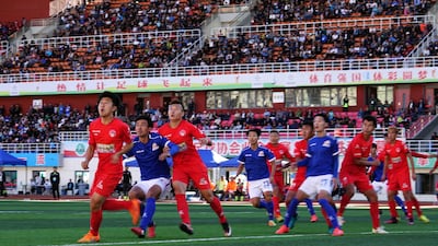 Players of the Lhasa Chengtou football club, in blue, in action against Zibo Sunday in Lhasa. AFP