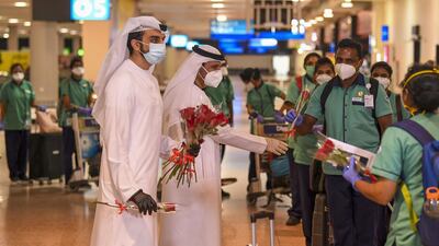 Emirati officials present roses to members of an Indian medical team upon their arrival at Dubai International Airport. AFP