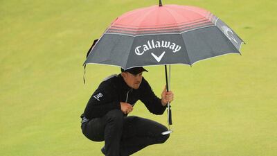 Henrik Stenson of Sweden uses an umbrella to shelter from the rain as he prepares to putt on the 8th green during the second round on day two of the 145th Open Championship at Royal Troon on July 15, 2016 in Troon, Scotland. (Photo by Mike Ehrmann/Getty Images)