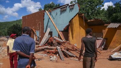 People survey a collapsed building in Chipinge, Zimbabwe. Getty Images