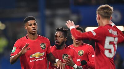 Manchester United's English striker Marcus Rashford, left, celebrates with teammates after scoring his team's first goal. AFP