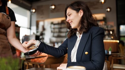 Female customer paying bill using a smartwatch