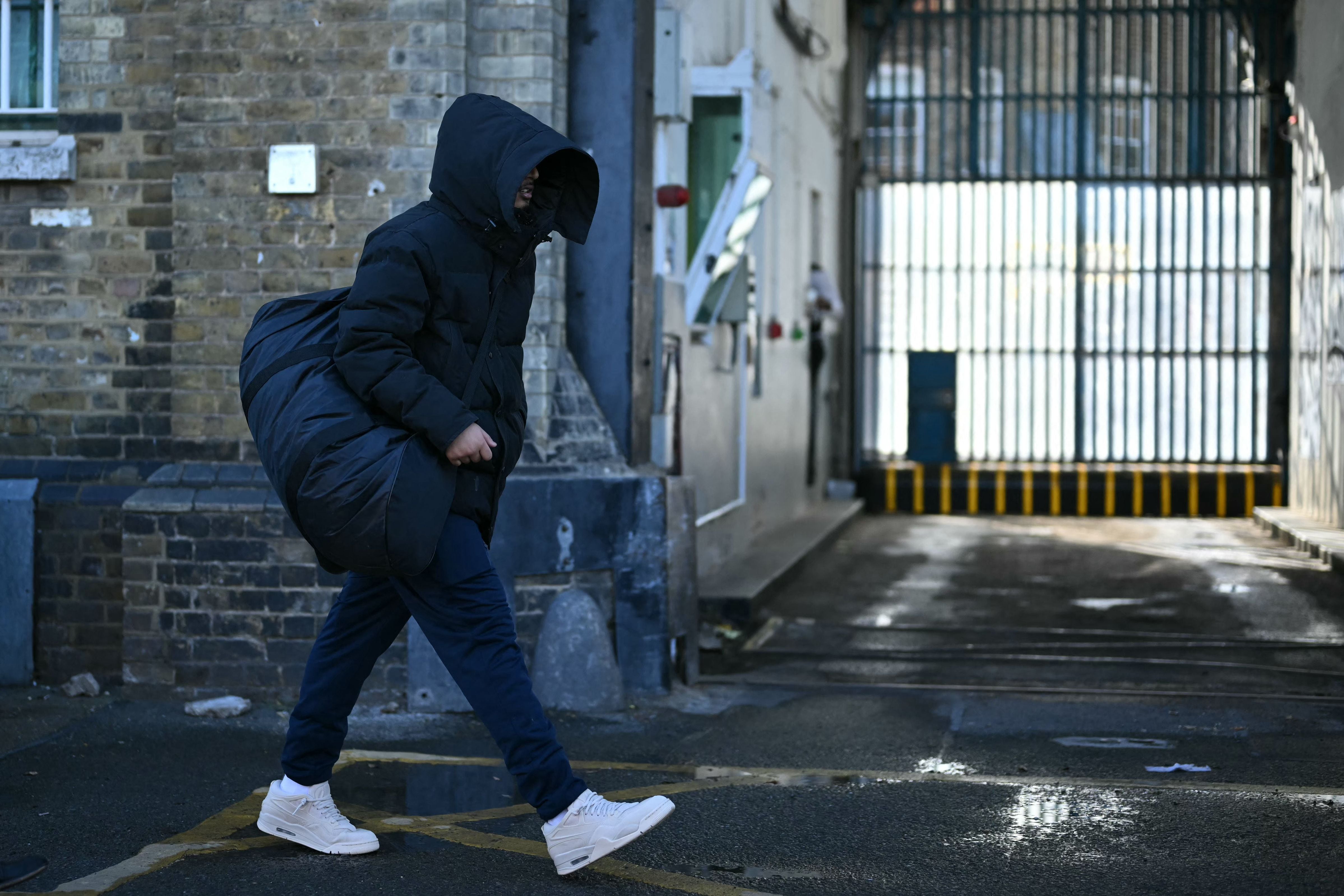 A released prisoner leaves Brixton prison in south London on October 13, 2026, during the second phase of a scheme to free up prison places. (Photo by JUSTIN TALLIS / AFP)