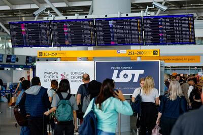 Passengers check their delayed flights on monitors at the international airport in Warsaw after the airport was closed due to Russian drones violating Polish airspace on Wednesday morning. AFP