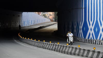 Motorists ride along a deserted road during the government-imposed nationwide lockdown against the spread of coronavirus, in Bangalore. AFP