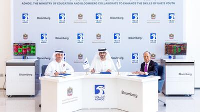 Dr Sultan Al Jaber, Minister of State and Adnoc Group chief executive, Dr Ahmad Al Falasi, Minister of State for Higher Education and Advanced Skills, and Michael Bloomberg, founder of Bloomberg LP, sign the agreement in Abu Dhabi. Courtesy Adnoc
