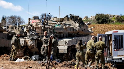 Israeli soldiers gather around their battle tanks near the border with Lebanon. AFP
