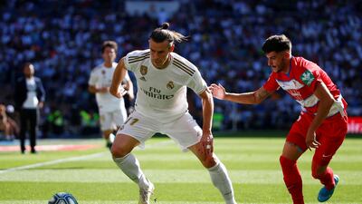 Real Madrid's Gareth Bale, left, in action with Granada's Carlos Neva, Reuters