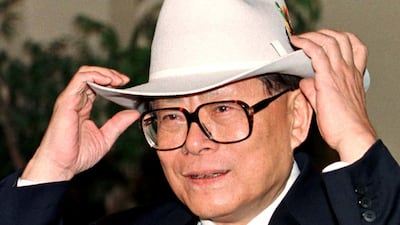 Jiang Zemin tries on a cowboy hat given to him by the mayor of Calgary, Al Duerr, in Canada, November 26, 1997. Reuters