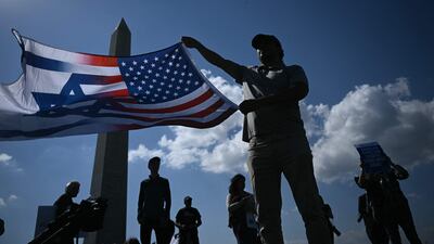 People hold flags during a rally and vigil near the Washington Monument. AFP