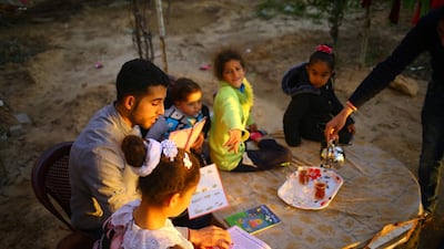 Mossab Abo Toha, who is collecting english books for his Library and Bookshop for Gaza project, reading English books with children in the garden at his family home in Beit Lahia in northern Gaza on February 20, 2017. Mohammed Abed/AFP