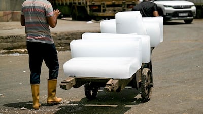 Workers carry ice blocks on a hand cart in New Delhi. Power usage in the city of almost 33 million people has surged as residents turn up air-conditioning systems to stay cool. AFP