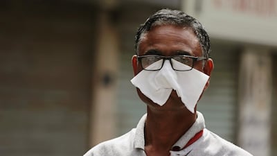 A man wears a piece of tissue to protect his face on a street in Manama. EPA