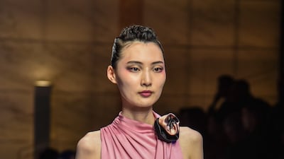 A rose pink silk dress knotted around the neck at Armani. EPA