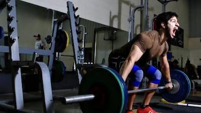 Emirati Marwan Al Marri does Olympic-style weightlifting training with his coach Derrick Branford, reflected in the mirror, at 24 Fitness, a gym in Al Quoz in Dubai. Sarah Dea / The National
