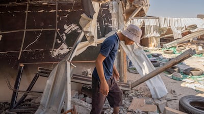A boy from Zanuta standing among the rubble of a school that was destroyed by Israeli settlers