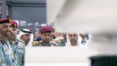 Delegates watch a demonstration of a self cleaning camera at Etimad Holding stand. Reem Mohammed / The National