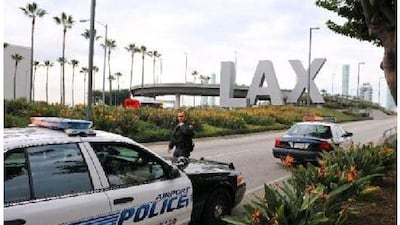 A police officer walks to his patrol car at a security checkpoint near the entrance to Los Angeles International Airport.