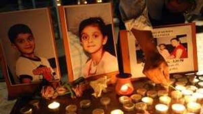 A mourner lights a candle at St Mary's Catholic church in Dubai during last night's vigil for Nathan and Chelsea D'Souza, the children who died of suspected food poisoning this month.
