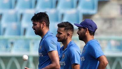 India's Avesh Khan, left, prepares to bowl as teammates Bhuvneshwar Kumar, right, Harshal Patel watch during a practice session. AP