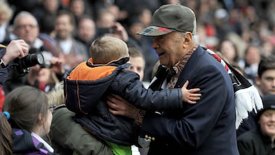 As Fulham FC chairman, Mr Al-Fayed picks up a young fan during a match in London in 2012. Getty Images
