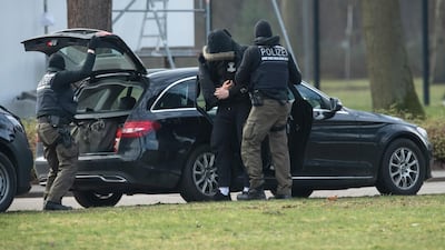 An unidentified person is brought to court by police officers after German authorities broke up an alleged right-wing terror group. DPA/AP