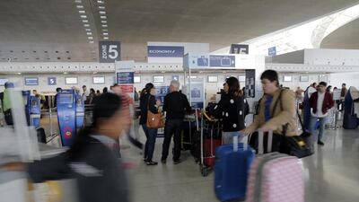 Travelers walk past Air France desk at Paris Charles de Gaulle airport. Air France pilots have begun a week-long strike, affecting more than 50 per cent of scheduled flights. Christophe Ena / AP Photo
