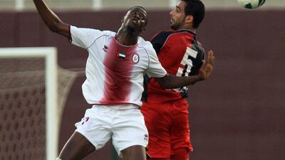 Al Wahda's Papa Waigo, in white and Al Shaab's Omar Al Shehhi jump for the ball. Ravindranath K / The National