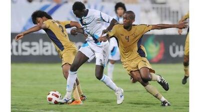 Andre Senghor, centre, the Baniyas forward, takes on the Dubai defence last night during his side's 2-0 victory.