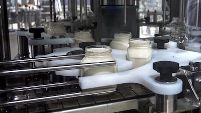 Sterilised glass containers are filled with spreadable cheese on the automated production line. Victor Besa / The National