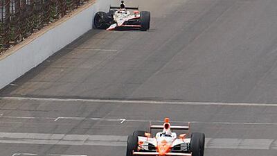 JR Hildebrand, who struck the wall exiting Turn 4 while leading on the last lap, watches helplessly as Dan Wheldon roars past to win the 100th Indianapolis 500, his second victory at the 2.5-mile oval.