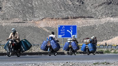 People transport jerrycans filled with smuggled Iranian petrol on their motorcycles, on the outskirts of Quetta in Balochistan province. AFP