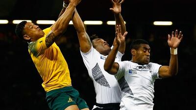 Israel Folau of Australia jumps for the ball with Fiji players Metuisela Talebula and Asaeli Tikoirotuma during their match at the 2015 Rugby World Cup on Wednesday. Dan Mullan / Getty Images