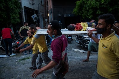 An injured man is carried on a piece of wood after the explosion ripped through Beirut. Getty Images