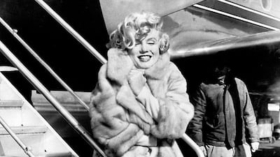 Marilyn Monroe poses in 1959 for the photographers at La Guardia Airport before flying to Chicago, for the presentation of her film Some like it Hot. AFP
