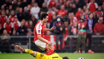 Denmark's Thomas Delaney, top, and Austria's goalkeeper Daniel Bachmann. AP