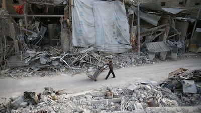 A man pushes a cart past damaged buildings at the besieged town of Douma, Eastern Ghouta, Damascus, Syria on March 5, 2018. Bassam Khabieh / Reuters