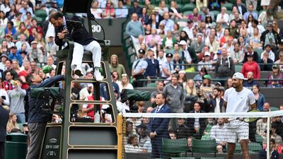 Australia's Nick Kyrgios (R) looks at the umpire talking with an official of the tournament during his men's singles tennis match against Greece's Stefanos Tsitsipas on the sixth day of the 2022 Wimbledon Championships at The All England Tennis Club in Wimbledon, southwest London, on July 2, 2022. (Photo by Glyn KIRK / AFP) / RESTRICTED TO EDITORIAL USE