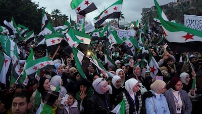 Syrians hold flags as they gather to mark the first anniversary of the fall of the regime of former president Bashar Al Assad, in Latakia, Syria. Reuters