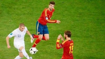 Gerard Pique, centre, and Sergio Ramos, right, will be manning the Spanish defence much the way did against Karim Benzema's France. Jeff Pachoud / AFP